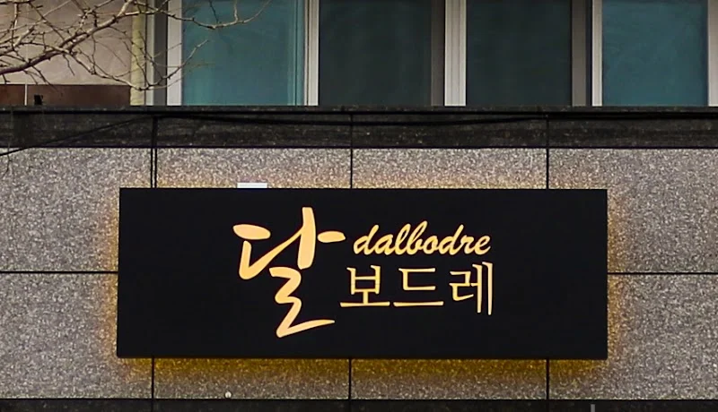  달보드레 · 검은 직사각형 간판과 따뜻하게 빛나는 상호 · 실제 시공 사진